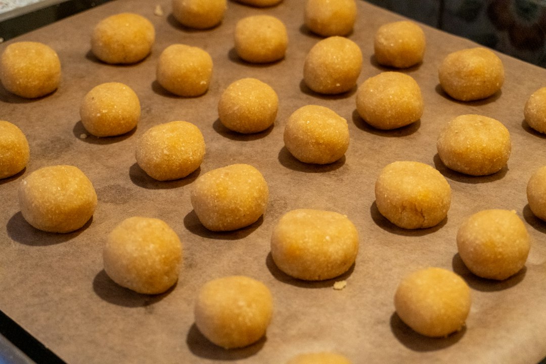 Cookie dough portions arranged on a parchment lined baking tray